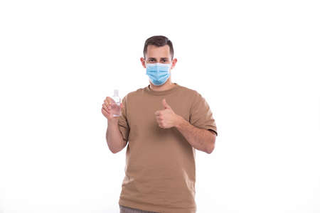 Man Holding Hands Sanitizer Wearing Medical Mask Isolatedの写真素材