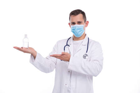 Man Doctor Holding Hands Sanitizer Pointing at It Wearing Medical Mask. Medicine, Virus, Doctor Conceptの写真素材