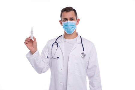 Doctor Holding Nose Spray Isolated. Man Doctor with Nasal Spray in Hands Wearing Medical Maskの写真素材