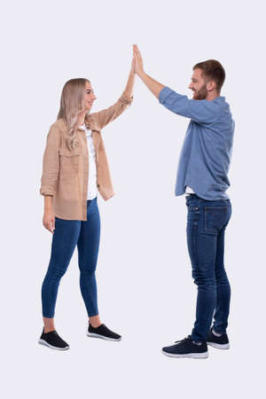 Young Couple Making High Five Standing Isolated. Signの写真素材