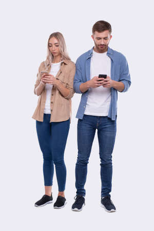 Couple Chatting on Phone. Couple Using Phones Standing Isolated. Couple Shopping Online. Techの写真素材