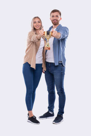 Couple Holding Trophy Happy Isolated. Couple Goals. Winners Standing Full Lenghtの写真素材