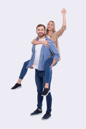 Girl Riding Man Back. Man Holding Girl. Couple Isolated. Girl on Man Back Sitting Hand Up. Loveの写真素材