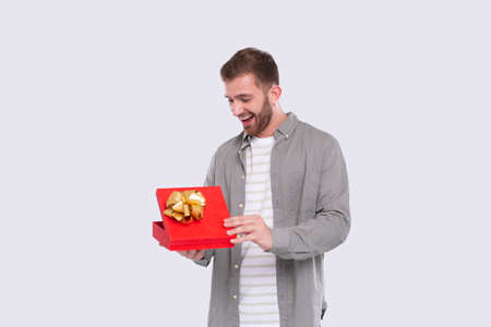 Man Holding Present Watching Whats inside. Man Holding Gift. Surprise. Gift Boxの写真素材