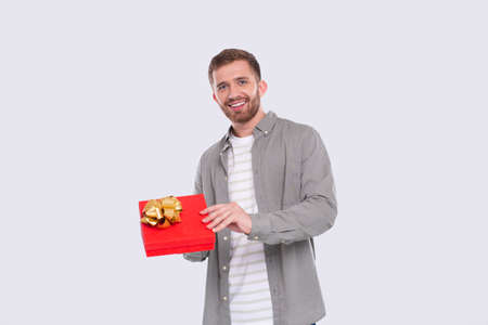 Man Holding Present Watching Whats inside. Man Holding Gift. Surprise. Looking to Cameraの写真素材