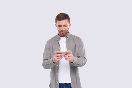 Man Playing Phone Games. Man Excited Playing Mobile games. Gamer Isolatedの写真素材