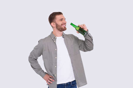 Man Holding Beer Bottle. Man With Beer Bottle in Hands. Alcohol Drink Bottle. Drinking Beer Standingの写真素材