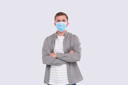 Man Wearing Medical Mask Hands Crossed Isolated. Man In Green Shirt with Medical Mask. Health, Virus, Medical Conceptの写真素材