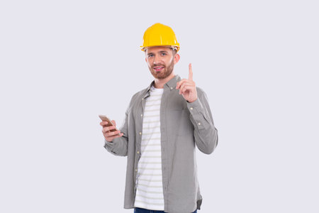 Construction Worker Having A Great Idea Holding Phone in Hands. Man with Idea Holding Finger Up....