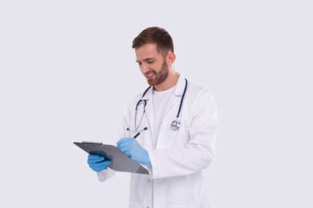 Man Doctor Writing in Clipboard Isolated. Doctor with Clipboard. Commecial, Shopping, Advertisment Concept Isolatedの写真素材