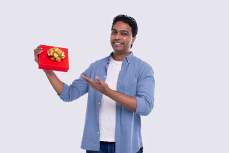 Indian Man Showing Present over Exceded. Man Holding Gift. Surprise. Gift Box. Very Happy Man Isolatedの写真素材