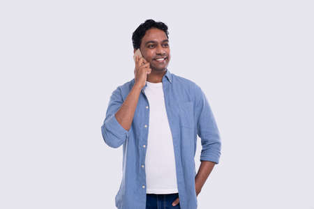 Indian Man Talking on Phone Standing Isolated. Commecial, Shopping, Advertisment Concept. Technologyの写真素材
