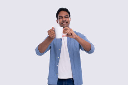 Indian Man Holding Tea Cup Showing Heart Gesture. Love Sign Coffee Cup. Man Tea or Coffee Lover Isolatedの写真素材