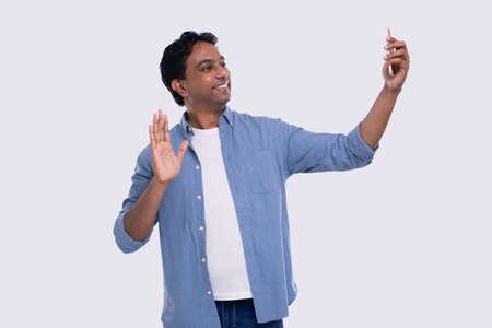 Indian Man Having Video Call on Phone Waving Isolated. Man Video Call. Man Using Phone. Isolatedの写真素材