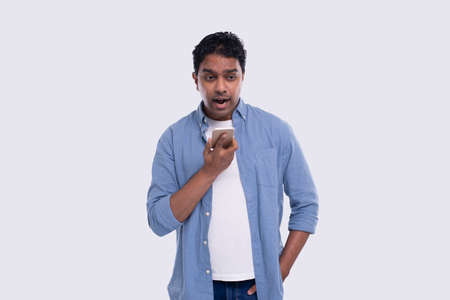 Indian Man Talking on Phone Standing Isolated. Angry Man Loudly speaking on Phone Commecial, Shopping, Advertisment Concept. Technologyの写真素材