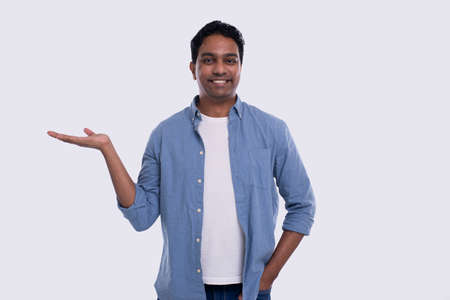 Man Holding Hand to Side Watching to Camera Isolated. Indian Man Smilling. Commercial, Advertisment Conceptの写真素材