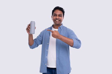 Indian Man Holding Tin Can Pointing at It. Indian Man With Beer Tin Can in Hand. Isolatedの写真素材