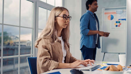 Girl Working on PC in Creative Office. Overworking Tired Girl. Over Hours in Office. Evening Workの写真素材