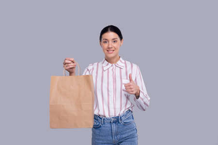 Girl Holding Shopping bag Showing Thumb Up. Girl Shopping. Shopping Concept Isolatedの写真素材