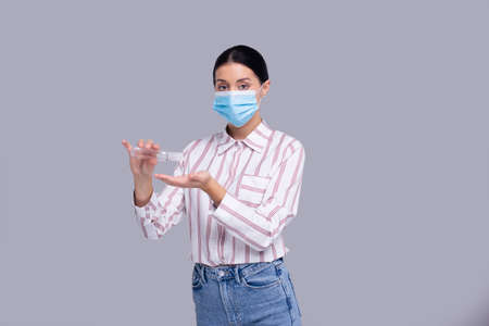 Girl Wearing Medical Mask Isolated. Girl Using Hands Sanitizer. Health, Virus, Medical Concept Isolatedの写真素材