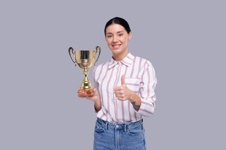 Girl Holding Trophy Showing Thumb Up Isolated. Girl Goals. Winner. Girl Smilling. Trophy in Girl Handsの写真素材