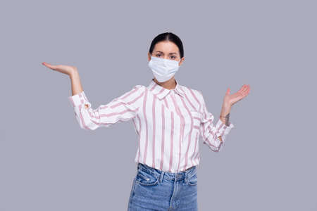 Girl Wearing Medical Mask Holding Hands to Side. Woman In Office look with Medical Mask. Health, Virus, Medical Concept Isolatedの写真素材