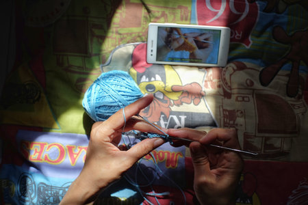 Klaten, Indonesia, Sept 13, 2020. Skilled hands make crafts from knitted yarn only armed with tutorials from streaming youtube contentのeditorial素材