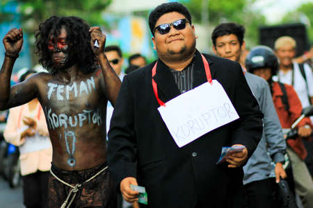 Yogyakarta, Indonesia, Dec 9, 2014. Anti-corruption activists carried out theatrical actions of bribery officials in a cultural parade to commemorate International Anti-Corruption Day.のeditorial素材
