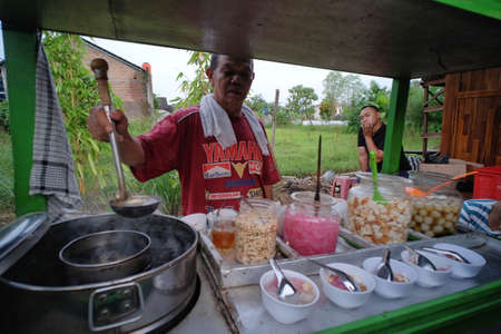 Yogyakarta, Indonesia, March 14, 2020. The seller prepares a traditional Wedang Ronde drink, warm and sweet ginger soup mixed with various toppingのeditorial素材