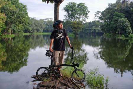 Yogyakarta, Indonesia, Jan 13, 2021. Cyclists while resting enjoy  cool morning air while enjoying the warmth of morning sun which gradually comes out in a hidden lake in Adisutjipto Airfield complex.のeditorial素材