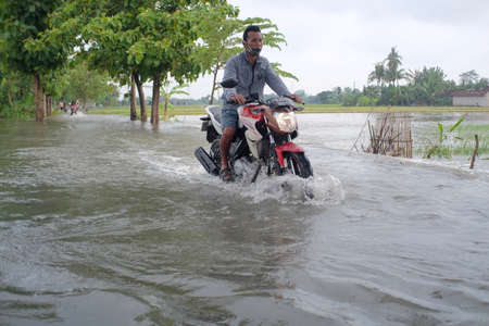 Klaten, Indonesia, 5 Feb 2021. Motorized vehicles passing through flood currents that overflowed from the river due to heavy rainfall.のeditorial素材