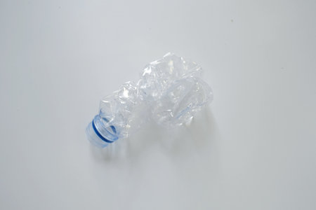Rubbish squeezed single-use bottled drinking water isolated on a white backgroundの写真素材