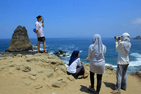 Jember, Indonesia, Sept 12, 2015. Local tourists visit Papuma Beach. Tanjung Papuma is a type of beach that has large waves as it faces directly to the Indian Ocean.のeditorial素材