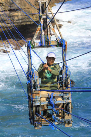 Yogyakarta, Indonesia, June 12, 2015. Using their own traditional cable car, shrimp fishermen cross the island every day to catch shrimp on the edge of a cliff.のeditorial素材