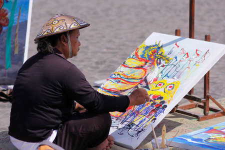 Yogyakarta, Indonesia, Jan 6, 2014. A painter draws a dragon-themed painting on canvas during the celebration of Dragon Festivalのeditorial素材