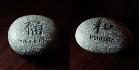 Letter happiness and harmony carved on stonesの写真素材