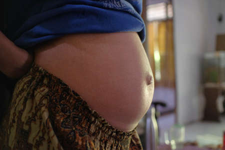 Klaten, Indonesia, July 29, 2021. The belly of a young mother who is pregnant is estimated to be three months old.の写真素材