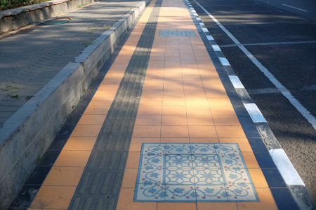 Pedestrian perspective with classic tiles on a paved roadside.の写真素材