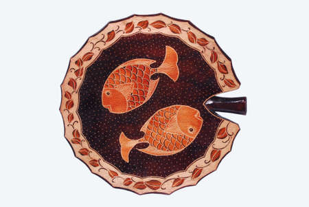 Decorative plate made of wood with a picture of a fish. Souvenirs of such handicraft products are usually wall decorations or displayed in the roomの写真素材