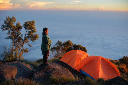 Temanggung, Indonesia, Aug 30, 2020. A climber enjoying the sunrise not far from his tent on Mount Sumbing.のeditorial素材