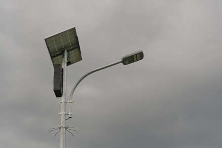 Street lighting uses solar power against a cloudy sky.の写真素材