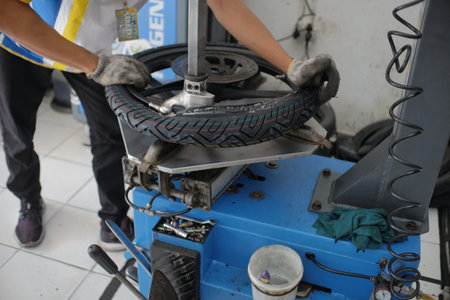 Klaten, Indonesia, June 7, 2020. A mechanic is installing a new motorcycle tire at a motorbike...
