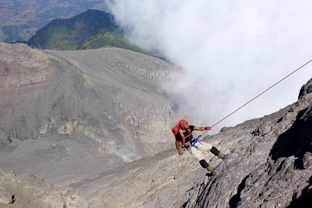 Yogyakarta, Indonesia, Oct 25, 2014. A young man was climbing a ridge of hills using a rope at Mount Merapi.のeditorial素材