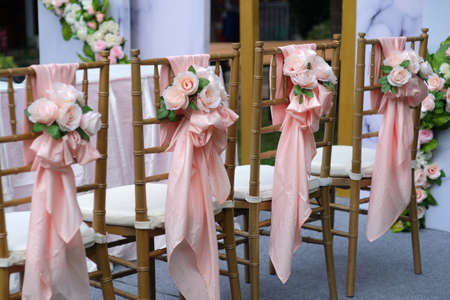 Chairs that have been decorated with fabric arranged into beautiful flower shapes. Prepared for wedding events or celebration ceremoniesの写真素材