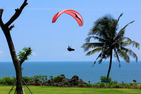 Yogyakarta, Indonesia, Feb 18, 2018. Paragliding athlete flies across the resort under the sunny weather in Jogja Air Show.のeditorial素材