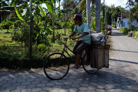 Central Java, Indonesia, April 8, 2019. An old man rides his old bicycle that has been modified to carry goods, Magelang.のeditorial素材