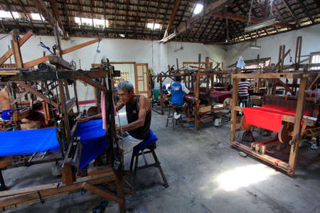 Yogyakarta, Indonesia, March 3, 2016. Skilled workers make woven fabrics using non-machine tools at the Lurik Kurnia weaving factory.のeditorial素材