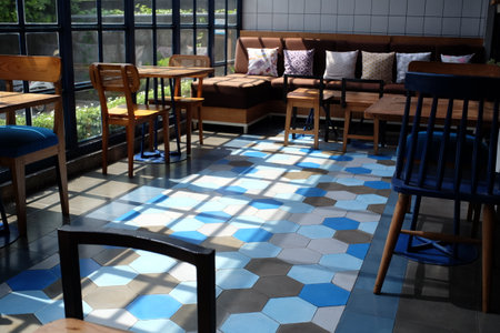 Yogyakarta, Indonesia, June 27, 2019. Set of sofa and wooden table chairs in an industrial-style restaurant with abundant room light.の写真素材