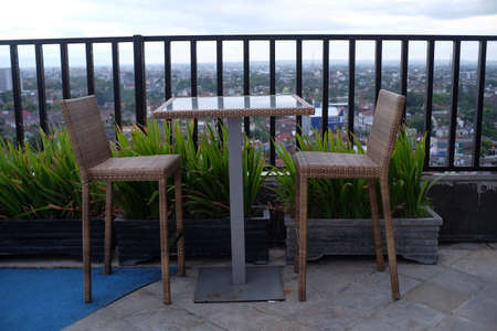 Chairs and tables for hanging out on a roof top hotel with an open air concept.の写真素材