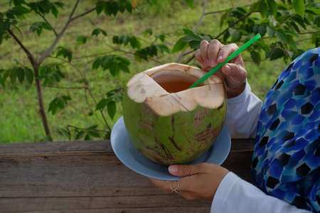 Enjoying coconut which is refreshing and effective as a detox for toxins in the body.の写真素材